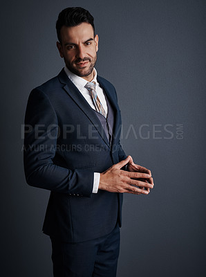 Buy stock photo Studio shot of a stylish and confident young businessman posing against a gray background