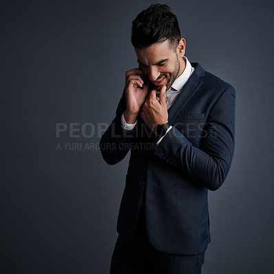 Buy stock photo Studio shot of a stylish young businessman using a mobile phone against a gray background