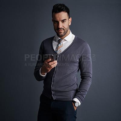 Buy stock photo Studio shot of a stylish young businessman using a mobile phone against a gray background