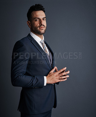 Buy stock photo Studio shot of a stylish and confident young businessman posing against a gray background