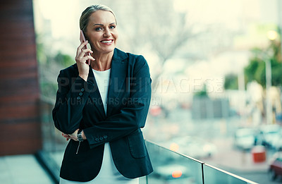 Buy stock photo Portrait of a mature businesswoman standing outside on the balcony of an office and using a mobile phone