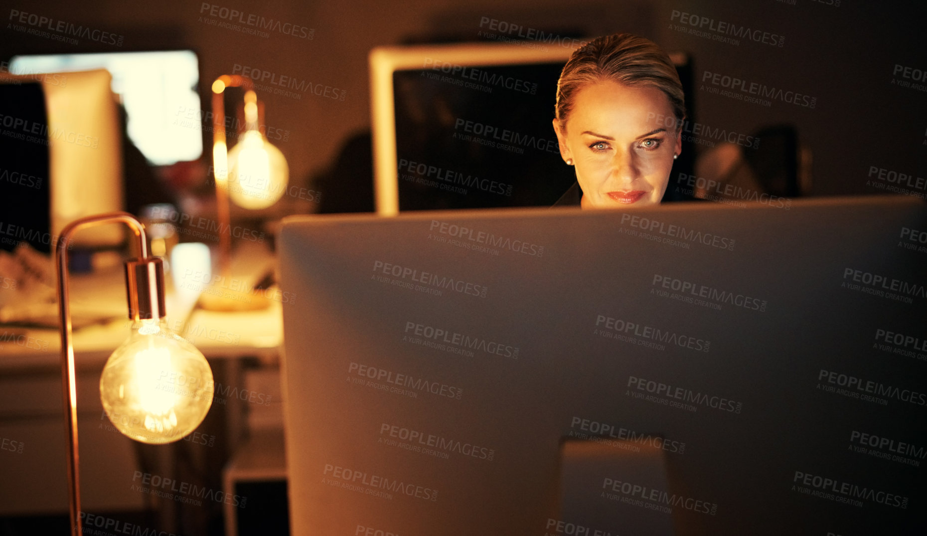 Buy stock photo Shot of a mature businesswoman working late at the office 
