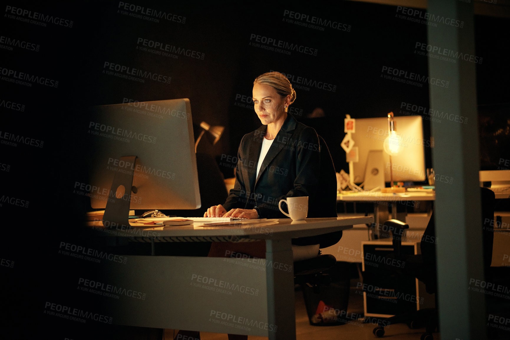 Buy stock photo Night, woman and reading in office with computer, report deadline and investigation for journalism. Late, mature person and research in workplace with desktop, review or fact check story for website.