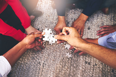 Buy stock photo Shot of a group of unidentifiable businesspeople building a puzzle together
