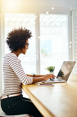 Buy stock photo Shot of a cheerful young woman working on her laptop at home
