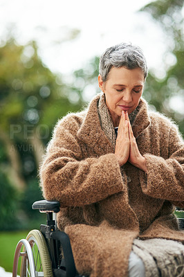 Buy stock photo Cropped shot of a senior woman praying while sitting in her wheelchair outdoors