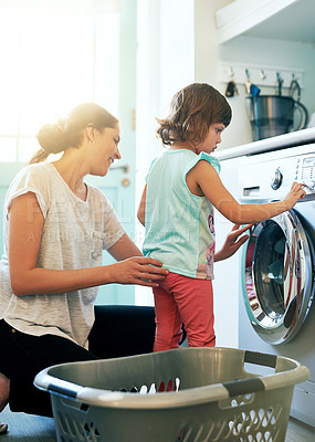 Buy stock photo Help, laundry and mom with kid at washing machine for chores, teaching and learning housekeeping routine. Home, mother and daughter cleaning clothes together with support, care and child development.