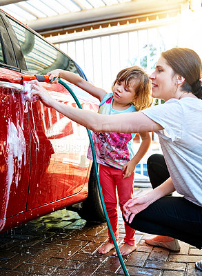 Buy stock photo Mother, child and washing car with hose pipe, water or soap for shine, chores or clean vehicle in garage. Little girl or kid helping mom with housekeeping, hygiene or bacteria, dirt or germ removal