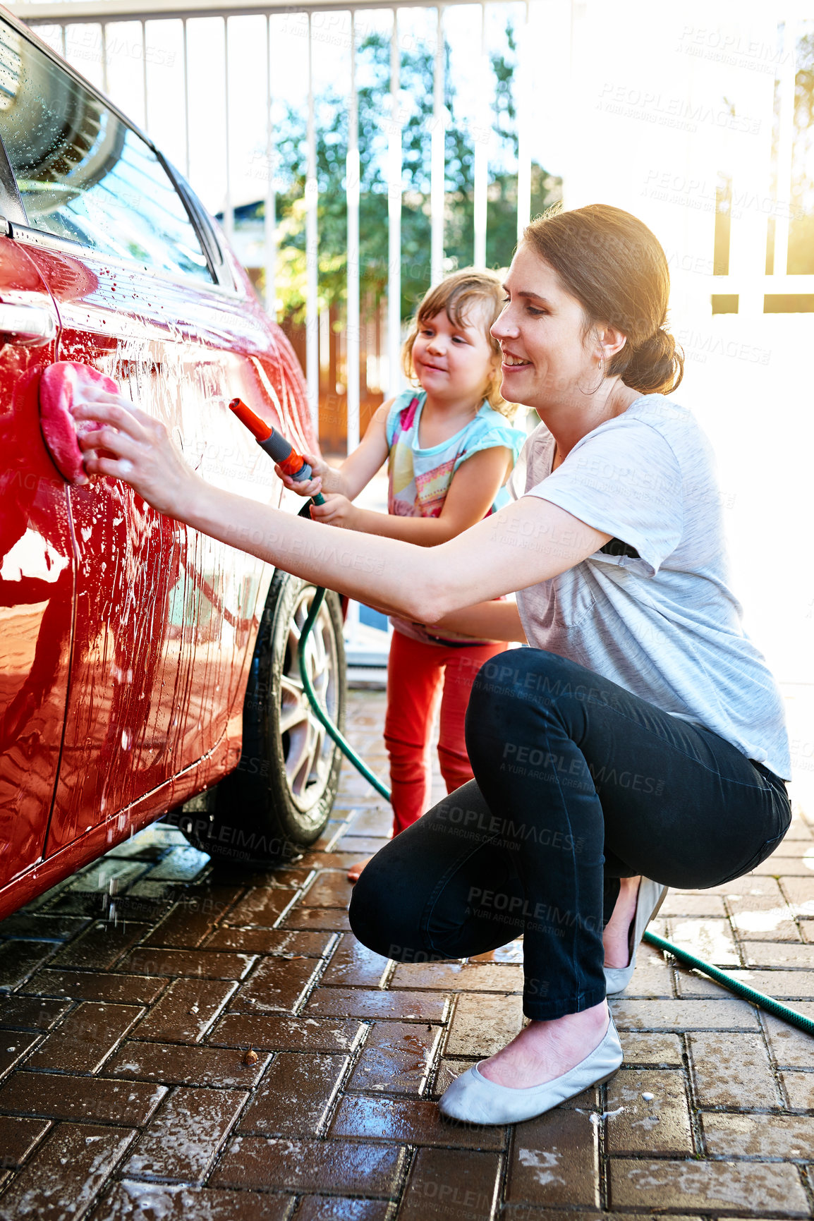 Buy stock photo Mom, kid and happy with washing car or teaching for child development, growth and childhood memories. Parent, girl and enjoy with bonding, fun and educational for social learning or support at home