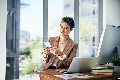 Buy stock photo Portrait of a businesswoman using her cellphone while working in an office