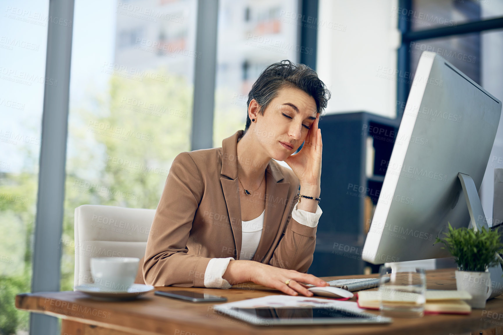 Buy stock photo Shot of a businesswoman looking stressed out while working in an office