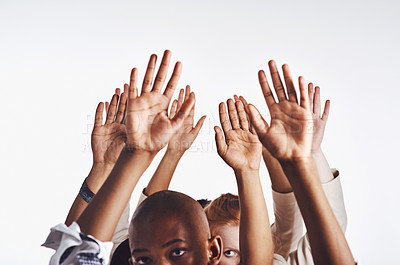 Buy stock photo Young, group and children with hands for answer, community freedom or protest together on a white studio background. Kids, youth or diverse people reaching up in air for support on mockup space