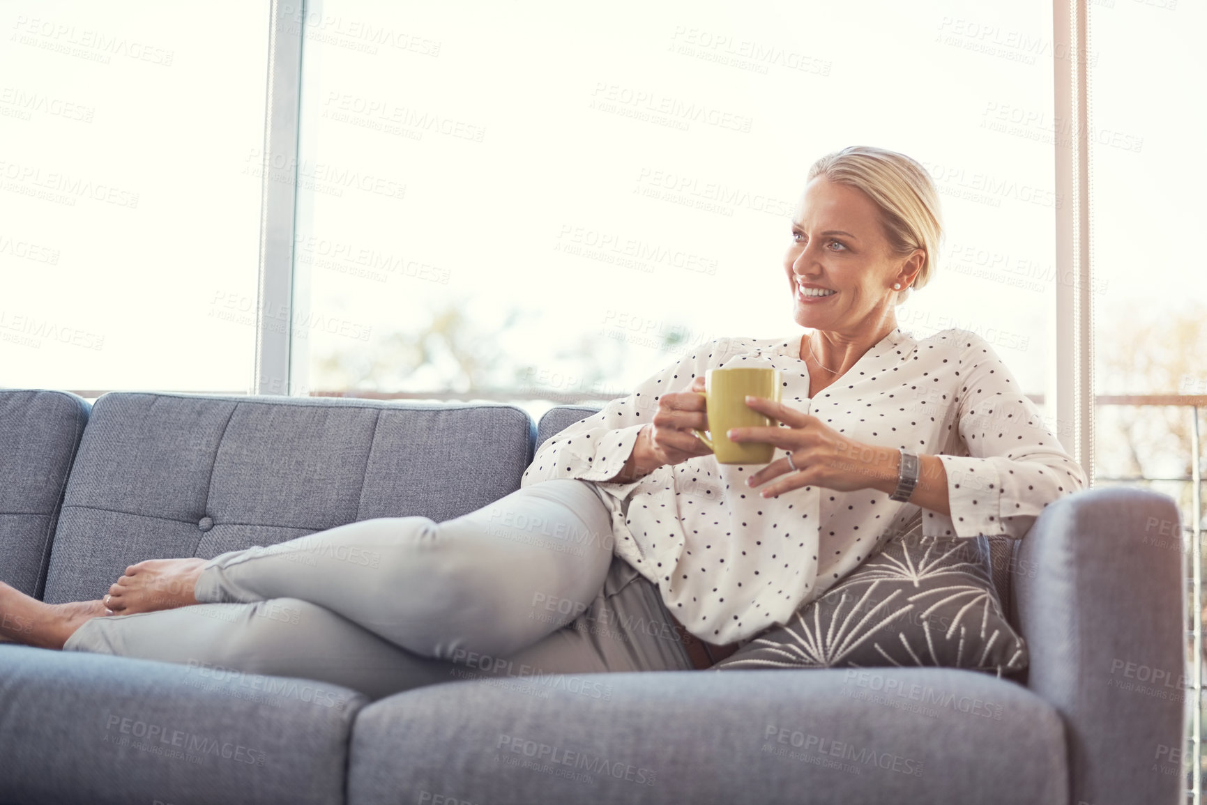 Buy stock photo Shot of a happy mature woman relaxing on the sofa at home