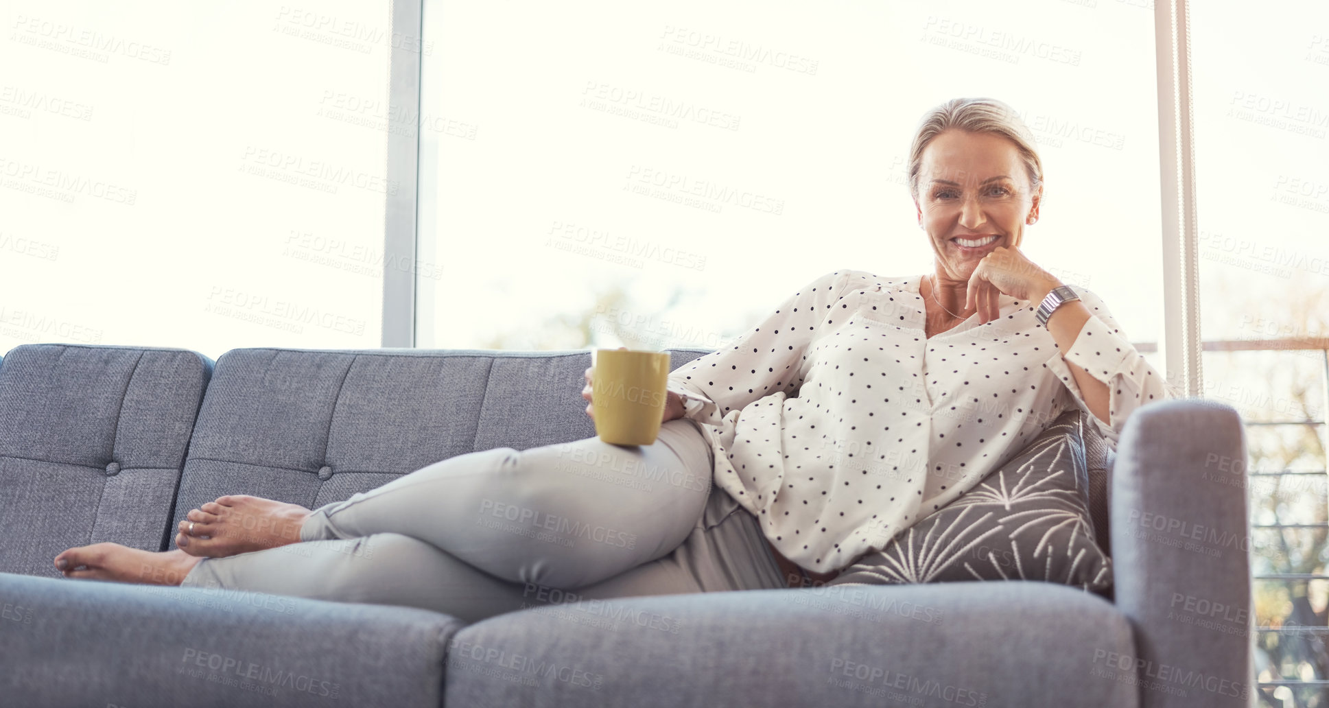 Buy stock photo Shot of a happy mature woman relaxing on the sofa at home