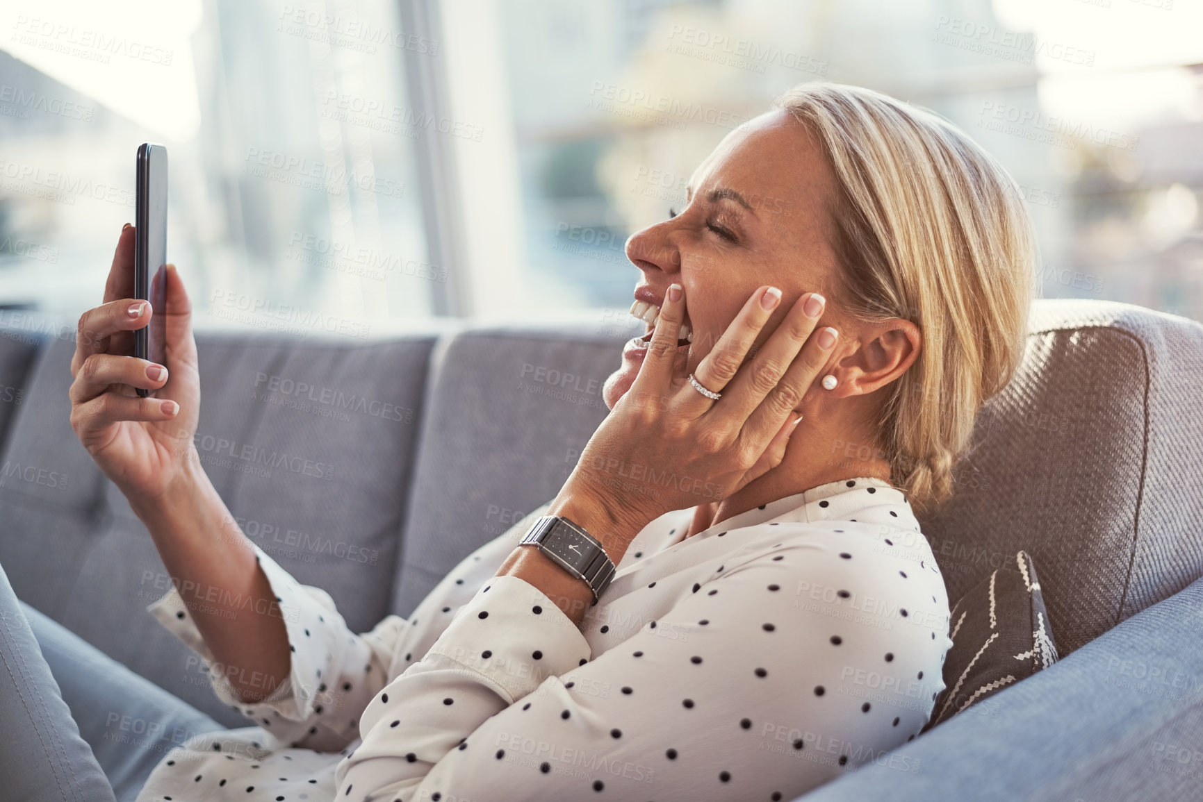 Buy stock photo House, funny and happy woman on sofa, smartphone and digital app for social media. Smile, laughing and person on couch, cellphone and email for online dating request, humor or message to contact