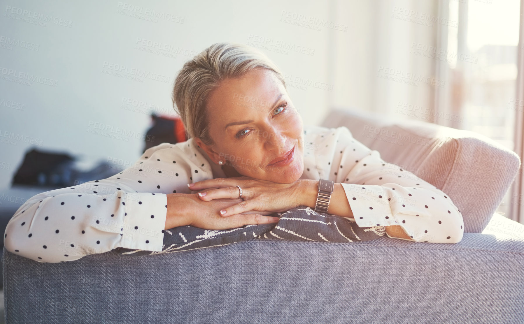 Buy stock photo Shot of a happy mature woman relaxing on the sofa at home