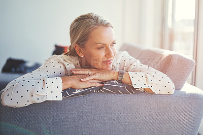 Buy stock photo Shot of a happy mature woman relaxing on the sofa at home