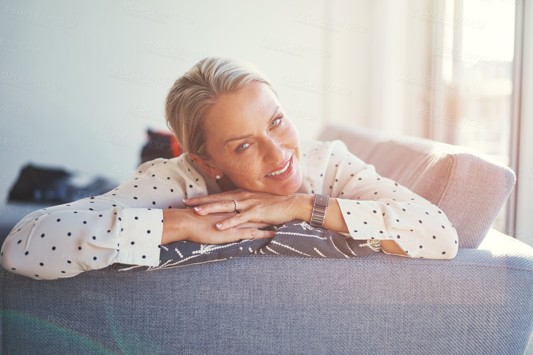 Buy stock photo Shot of a happy mature woman relaxing on the sofa at home