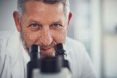 Buy stock photo Portrait of a mature scientist using a microscope in a laboratory