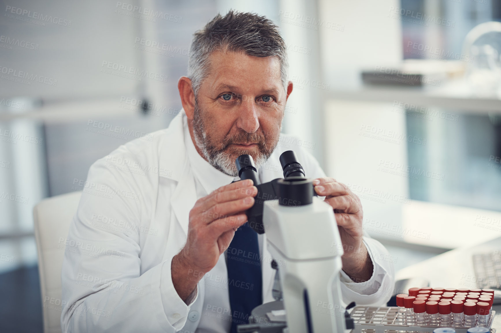 Buy stock photo Portrait of a mature scientist using a microscope in a laboratory