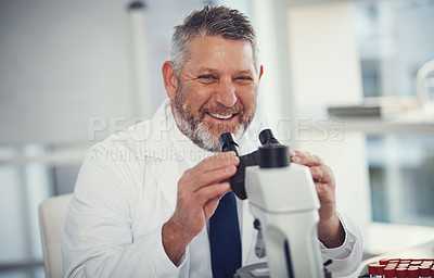 Buy stock photo Portrait of a mature scientist using a microscope in a laboratory