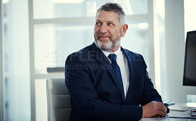 Buy stock photo Shot of a mature businessman working at his desk in a modern office