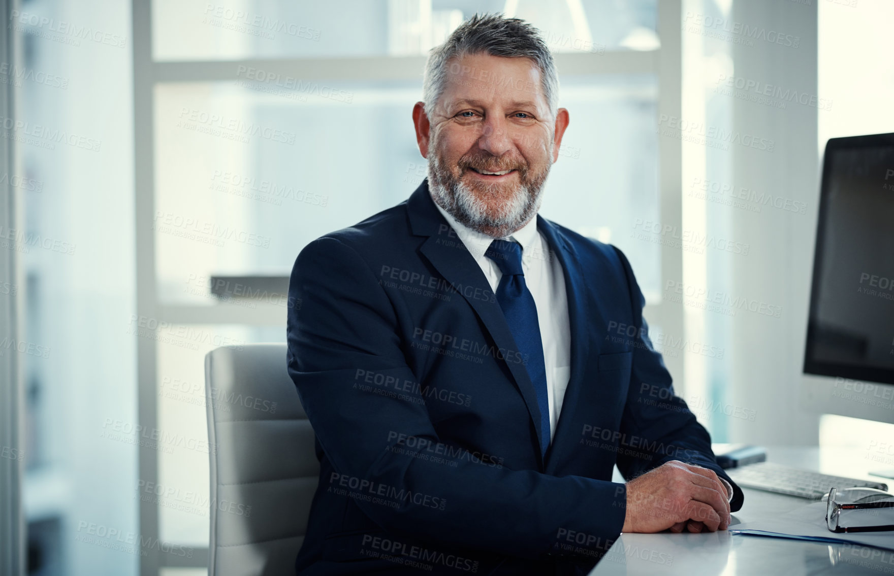 Buy stock photo Portrait of a mature businessman working at his desk in a modern office