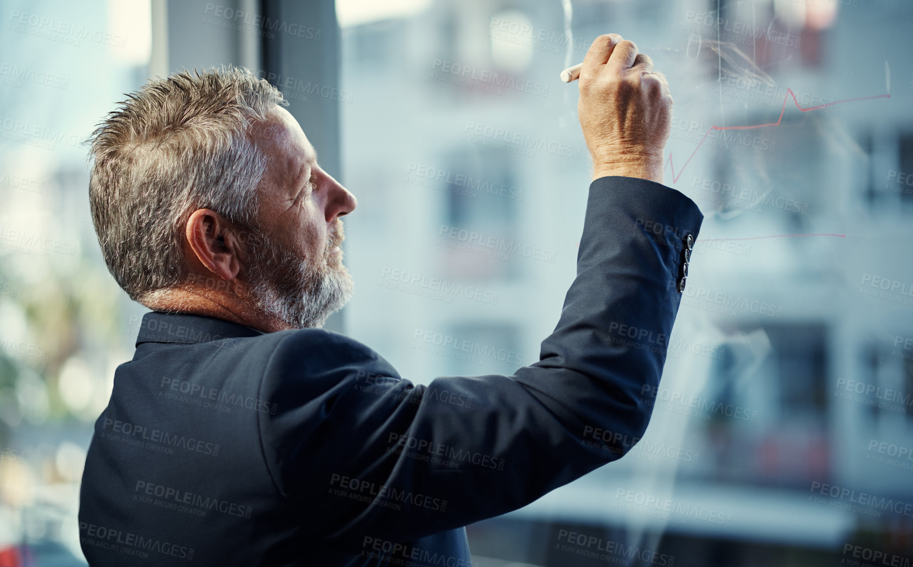 Buy stock photo Shot of a mature businessman having a brainstorming session against a glass screen in a modern office