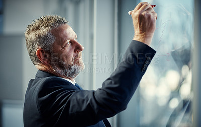 Buy stock photo Shot of a mature businessman having a brainstorming session against a glass screen in a modern office