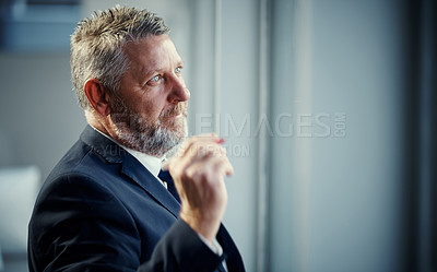 Buy stock photo Shot of a mature businessman having a brainstorming session against a glass screen in a modern office