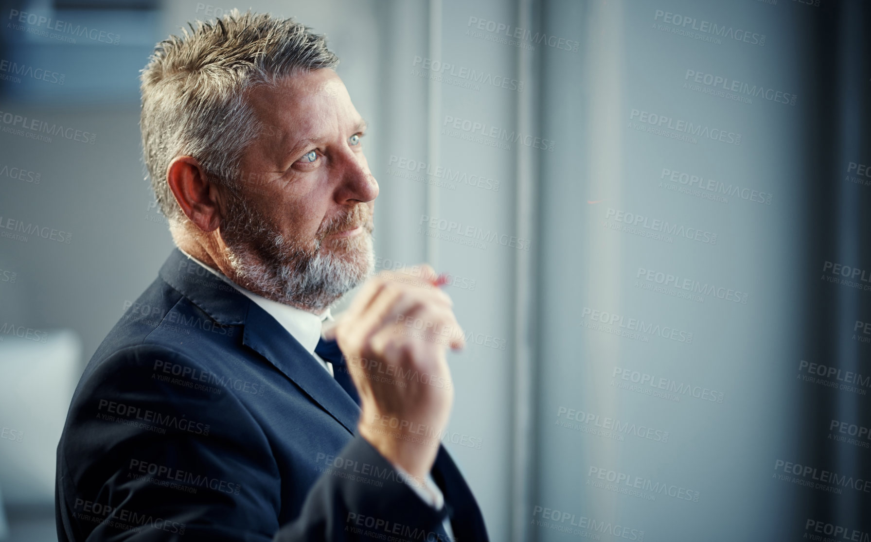 Buy stock photo Shot of a mature businessman having a brainstorming session against a glass screen in a modern office