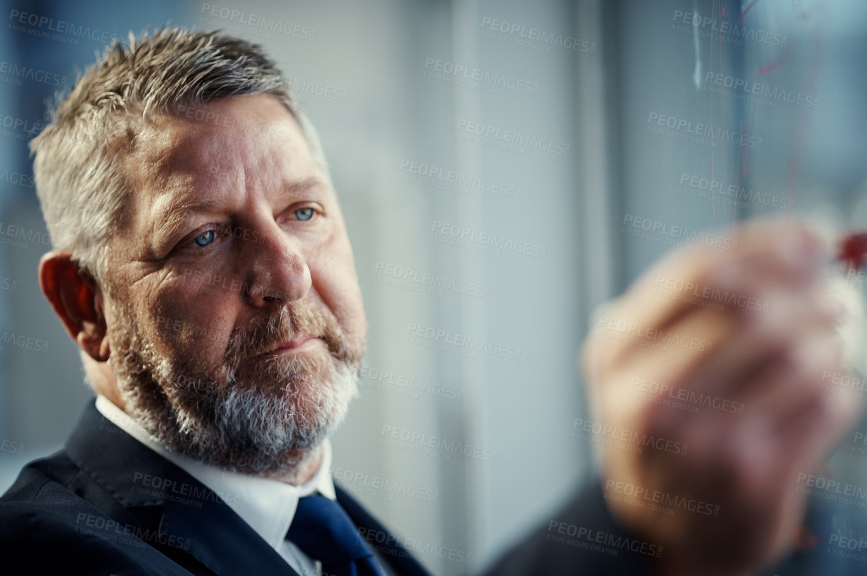 Buy stock photo Shot of a mature businessman having a brainstorming session against a glass screen in a modern office