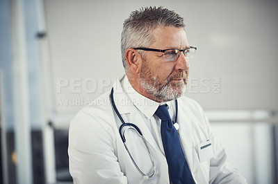 Buy stock photo Shot of a mature doctor using a computer at a desk in his office