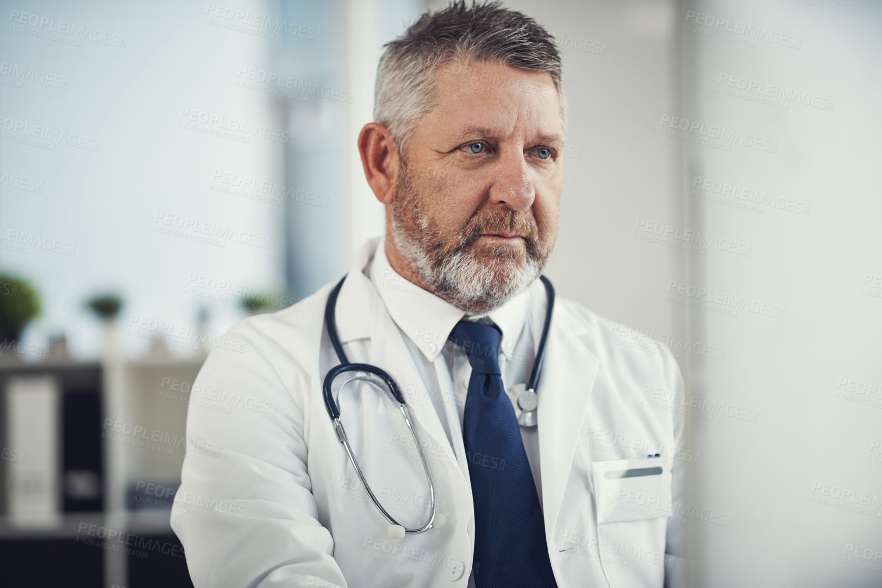 Buy stock photo Shot of a mature doctor using a computer at a desk in his office