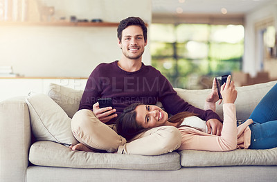 Buy stock photo Tablet, phone and portrait of couple on sofa in living room for entertainment together relaxing at home. Happy, love and people networking on cellphone and digital technology in lounge at apartment.