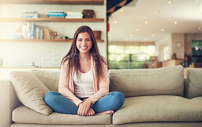 Buy stock photo Portrait of a cheerful young woman relaxing on the sofa with her legs crossed at home