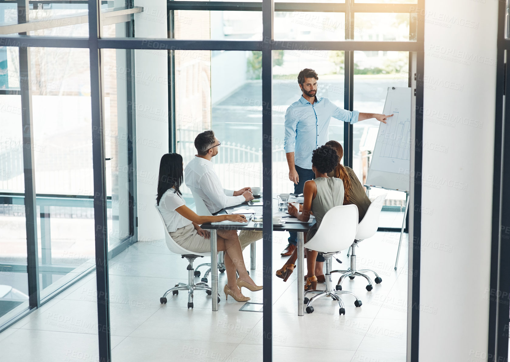 Buy stock photo Shot of a businessman giving a presentation to his colleagues in a modern office