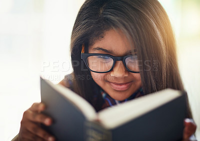 Buy stock photo Shot of a cute little girl reading a book in her bedroom