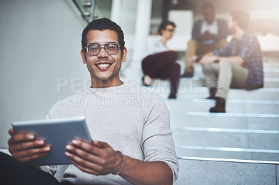 Buy stock photo Portrait of a young designer using a digital tablet with his colleagues in the background