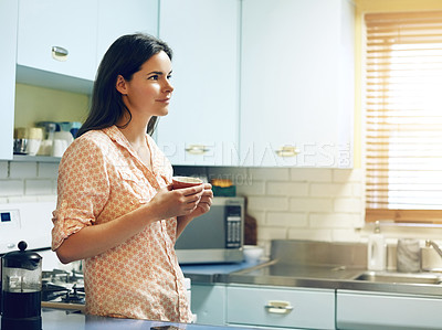 Buy stock photo Shot of an attractive young woman having a cup of coffee at home