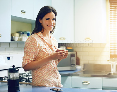 Buy stock photo Portrait of an attractive young woman having a cup of coffee at home