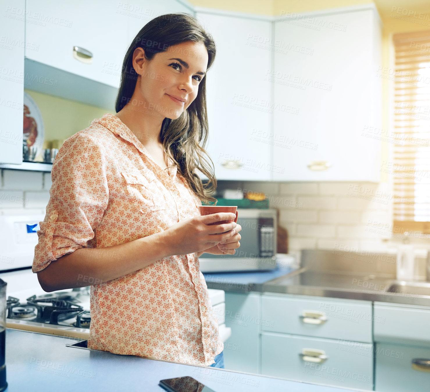 Buy stock photo Shot of an attractive young woman having a cup of coffee at home