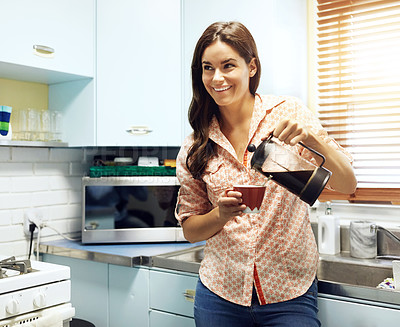 Buy stock photo Shot of an attractive young woman pouring a cup of coffee at home