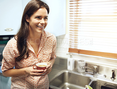 Buy stock photo Shot of an attractive young woman having a cup of coffee at home