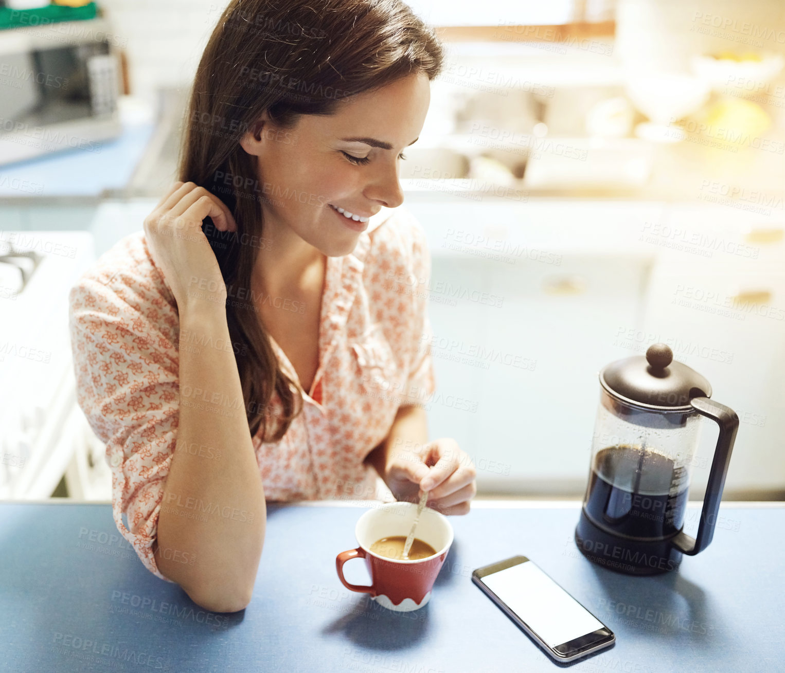Buy stock photo Morning, woman and smile with coffee in kitchen to start day, phone notification and reading news. Happy, person and relax with beverage in home for caffeine break, check smartphone alert or message