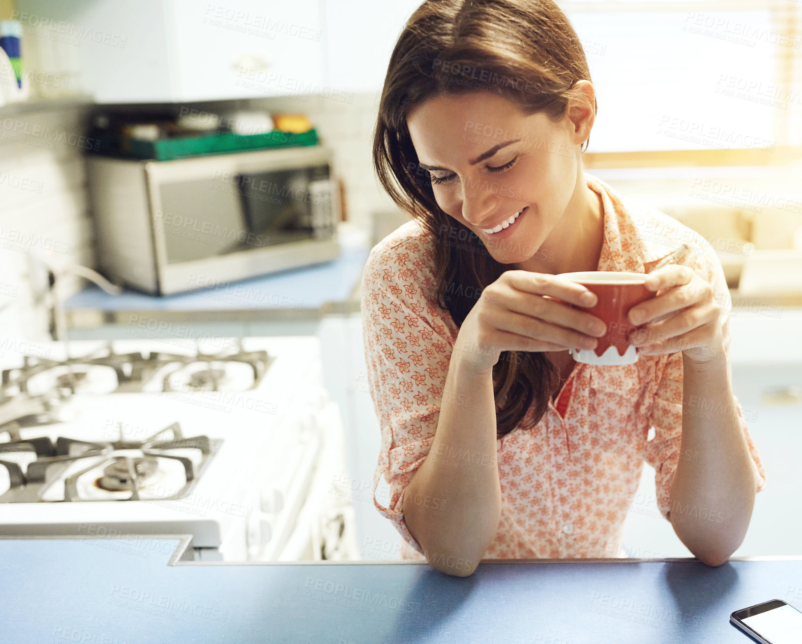 Buy stock photo Shot of an attractive young woman having a cup of coffee at home