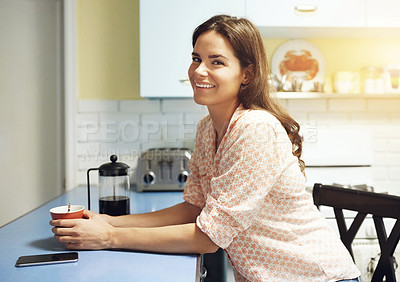 Buy stock photo Portrait of an attractive young woman having a cup of coffee at home