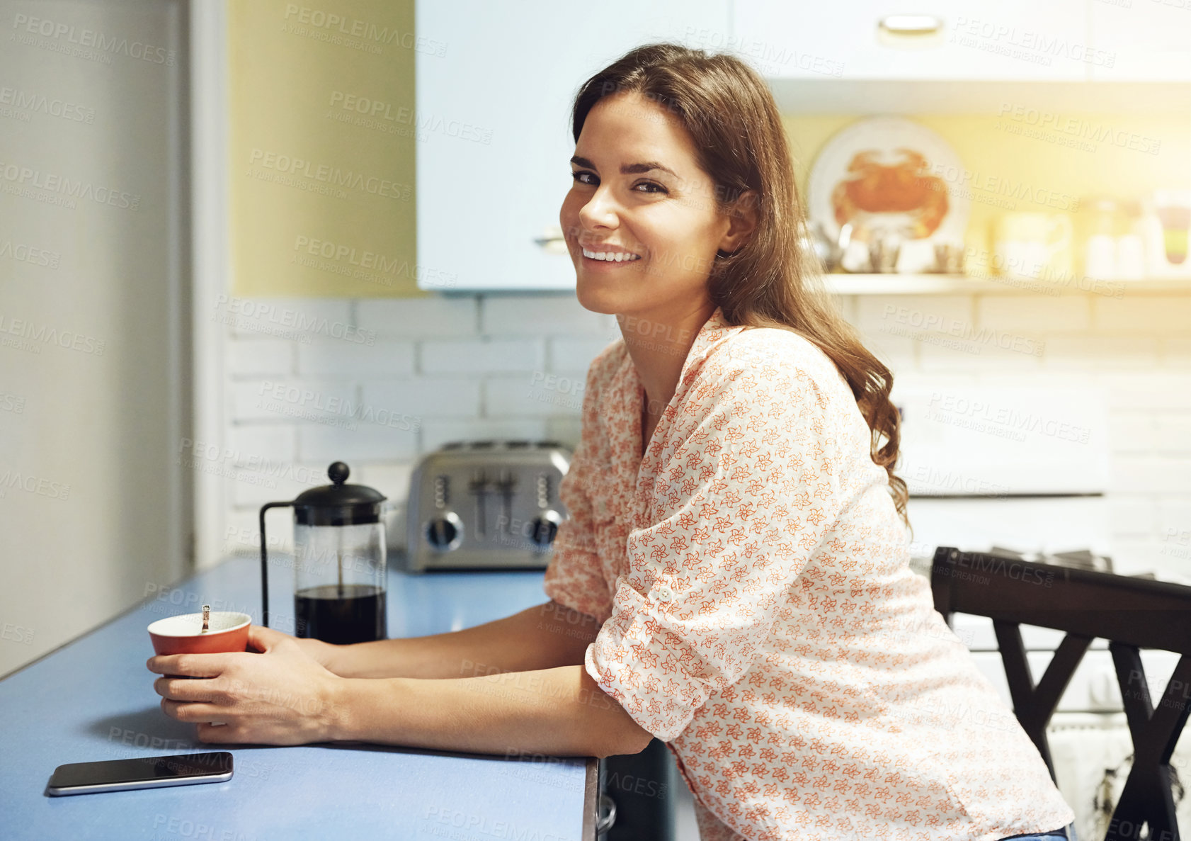 Buy stock photo Portrait of an attractive young woman having a cup of coffee at home