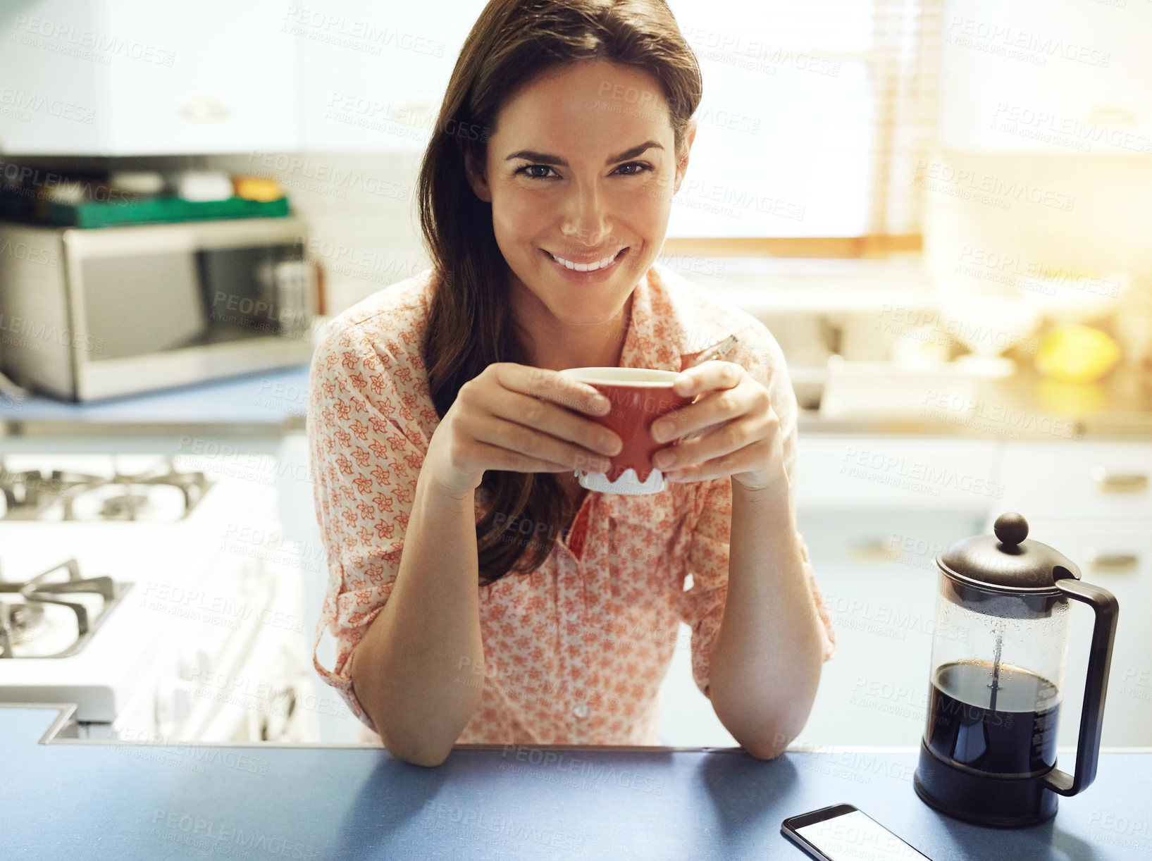 Buy stock photo Portrait of an attractive young woman having a cup of coffee at home