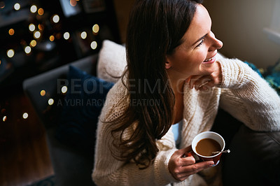 Buy stock photo Shot of an attractive young woman relaxing on the sofa with a cup of coffee at home